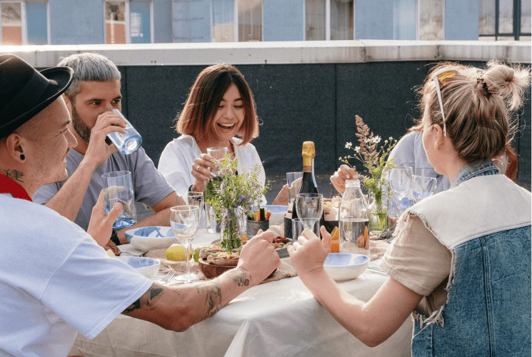 Group of people eating together while drinking water during a meal.