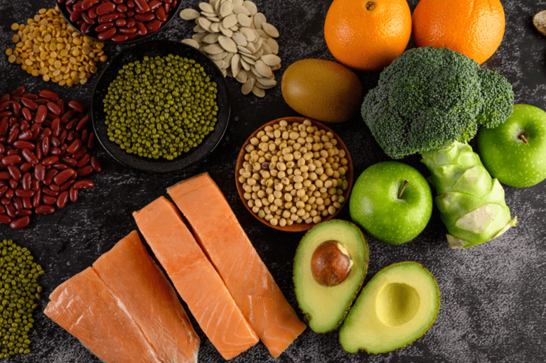 Fresh salmon fillet with green apples, grains, chickpeas, red beans, and nuts on a dark background.