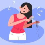 A worried woman looking at hair strands falling out while brushing, symbolizing hair loss concerns.